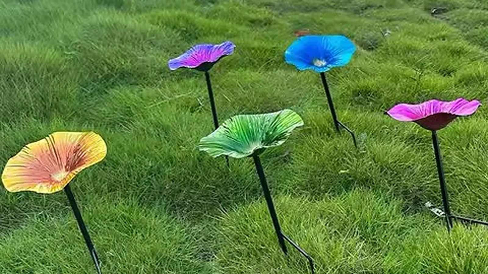 Flower-shaped bird bath stakes set in a lawn